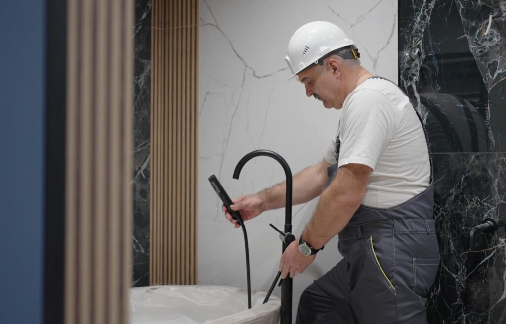 Plumber fixing water leaks in bathroom
